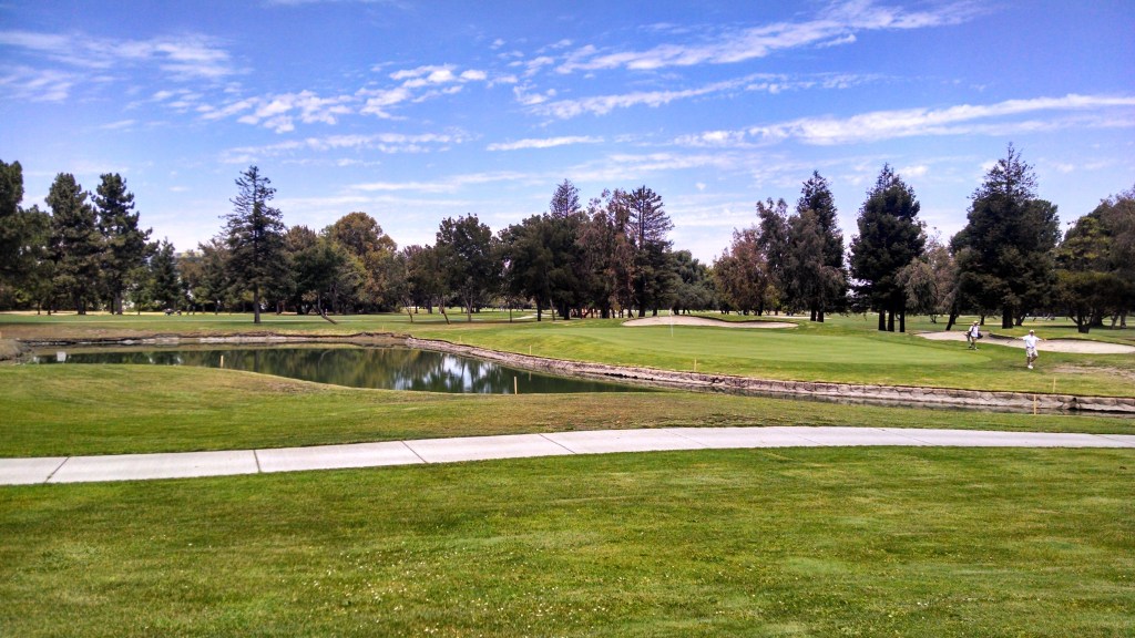 Course greens with sidewalk and lake